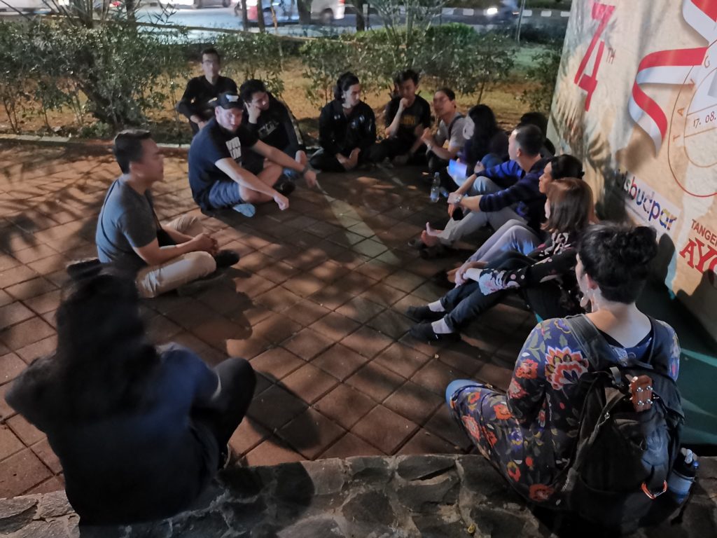 Group of people sitting for a debrief session after serving their community.